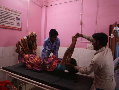 Familiares de Zamerun Nisha, de 33 años, depositan a la mujer en una camilla, después de que se sometiera a una cirugía de esterilización en un centro sanitario de Bahadurganj, en el noreste de India, el 21 de marzo de 2023.