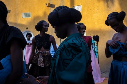Varias modelos se preparan en los camerinos, instantes antes de salir a desfilar por la pasarela de Dakar Fashion Week en la isla de Gorée. El evento, que este año ha festejado su vigésima edición, constituye una gran celebración cultural que ensalza la moda africana y la belleza negra sin complejos.