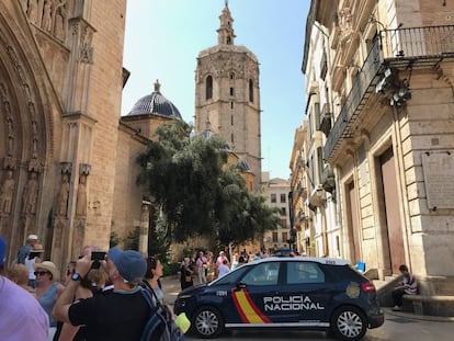 Un coche de polic&iacute;a corta el paso en la calle Micalet, junto a la catedral de Valencia.