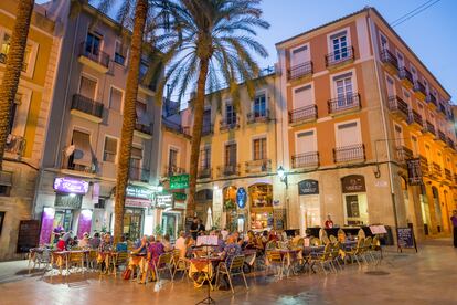 Varias personas cenan en una terraza, en Alicante.