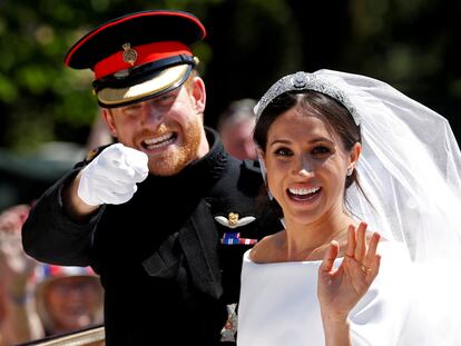 Príncipe Harry e Meghan Markle acenam para curiosos no casamento deles no castelo de Windsor.