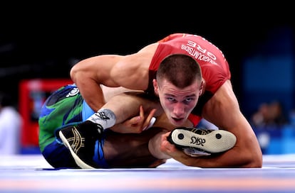 El griego Georgios Kougioumtsidis y Viktor Rassadin, de Tayikistán of Team Tajikistan, durante su combate de octavo de final de lucha libre, el decimocuarto día de Juegos Olímpicos.