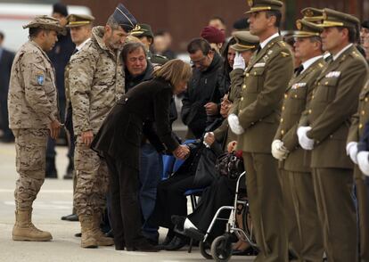 La ex ministra de Defensa, Carme Chacón, da el pésame a un familiar del sargento primero Joaquín Moya Espejo, muerto durante una enfrentamiento con insurgentes afganos en las inmediaciones de la localidad de Ludina, a la llegada del cadáver a la base aérea de Torrejón (Madrid), junto al ex jefe del Estado Mayor de la Defensa (JEMAD), José Julio Rodríguez (i), el 7 de noviembre de 2011.