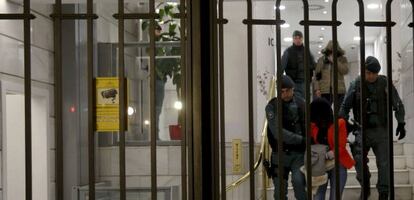 La Guardia Civil escolta a dos de los sospechosos de blanqueo durante el registro en la sucursal madrile&ntilde;a de ICBC. 