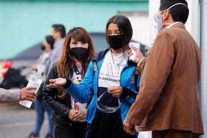 Estudiantes de nivel secundaria se toman la temperatura y se aplican gel antibacterial.