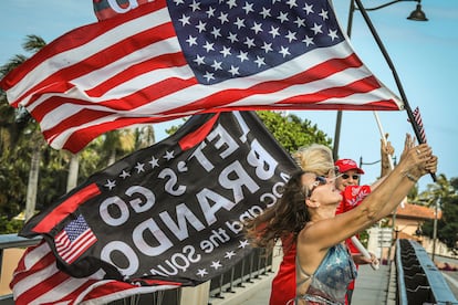 Simpatizantes de Trump apostados en el puente que lleva a su residencia de Mar-a-Lago, en Palm Beach, el 1 de abril. 