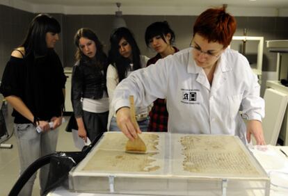 Una técnico del Archivo Histórico Provincial de Álava explica a unas estudiantes el proceso para la restauración de documentos antiguos en uno de los laboratorios del Archivo.