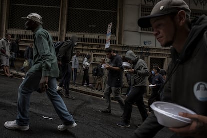 Cientos de personas se reúnen por las tardes a recibir un plato de comida por parte de los voluntarios en la región central de São Paulo.