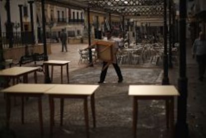 Un camarero recogiendo mesas en un restaurante en Sevilla. 