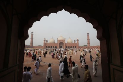 Musulmanes caminan cerca de la mezquita de Badshahi después de asistir a una oración masiva de Eid al-Adha, en Lahore, Pakistán.