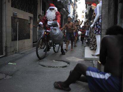 Un hombre vestido de Santa Claus reparte dulces y juguetes para los niños de la Favela da Mare, en Río de Janeiro.