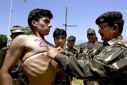 Un oficial indio mide el perímetro torácico de un recluta en un campamento militar de Cachemira.