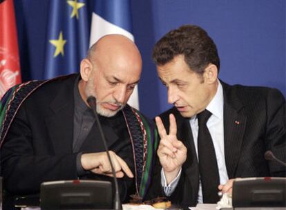 Sarkozy charla con el presidente Karzai durante la conferencia de París.