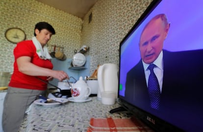 Una mujer cocina mientras mira por la televisión la ceremonia inaugural de Vladimir Putin, el 7 de mayo de 2018 en Moscú.