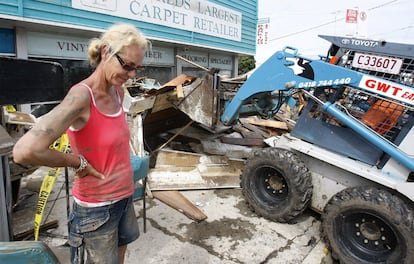 La lluvias han dejado más de 200.000 damnificados en el Estado de Queensland. En la imagen, la dueña de una carpintería a las puertas de su tienda realiza tareas de limpieza del barro y fango que ha dejado la crecida del río Brisbane a su paso por Ipswich.