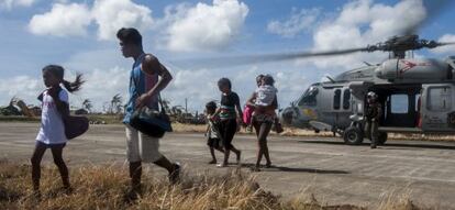 Varios afectados por el tifón en Filipinas, llegan a una zona más segura en Guiuan, tras ser trasladados por la Marina estadounidense. 