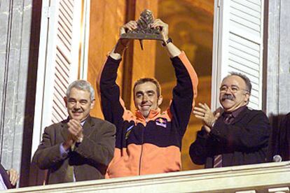 Roma, en el Palau de la Generalitat, entre Maragall y Carod, alza el trofeo de ganador del rally Dakar.