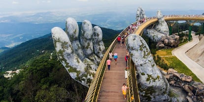 Vários turistas cruzam a Ponte Dourada.