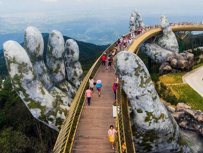 Vários turistas cruzam a Ponte Dourada.