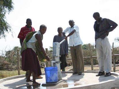 Miembros de una comunidad local latinoamericana sacando agua de un pozo, en un proyecto liderado por Ferrovial.