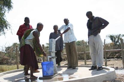 Miembros de una comunidad local latinoamericana sacando agua de un pozo, en un proyecto liderado por Ferrovial.