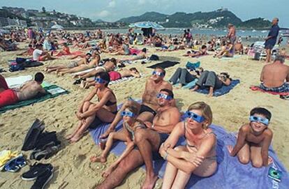 Bañistas toman el sol en la playa de La Concha.