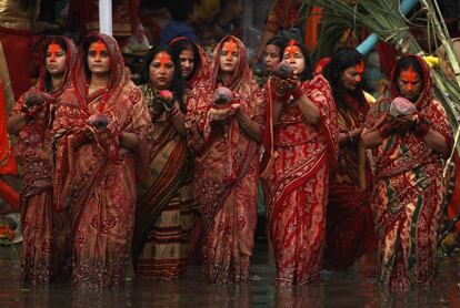 El sol, considerado el dios de la energía y de la fuerza vital, es objeto de culto durante este festival de Chhath para promover el bienestar, la prosperidad y el progreso. En la imagen, mujeres nepalíes realizan oraciones a la puesta del sol en el río Bagmati.