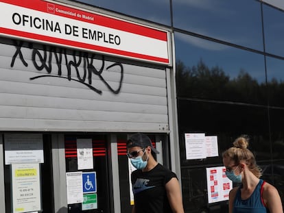 Dos jóvenes pasan ante una oficina de empleo en Madrid.