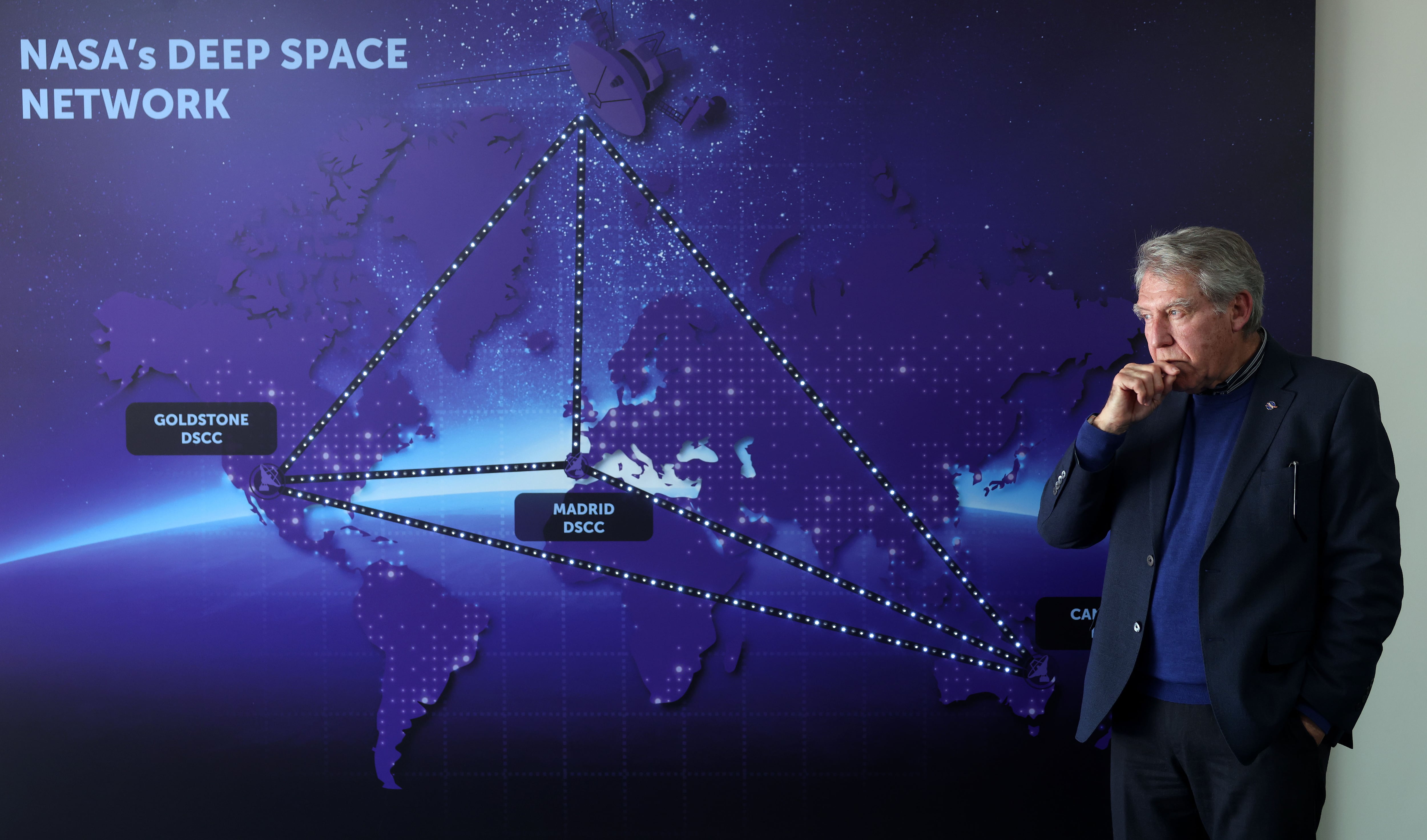 Moisés Manuel Fernández junto a un mapa que explica cómo funciona la Red del Espacio Profundo.