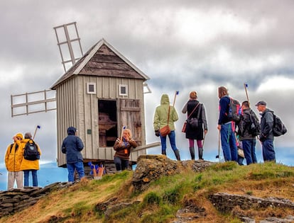 Turistas hacen fotos junto al molino de viento más antiguo de Islandia. Data de 1840 y ejerce de faro en la isla de Vigur, en la región de los Westfjords.