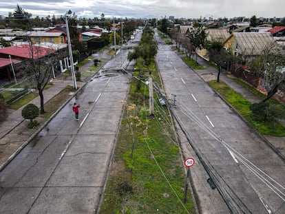 Un residente observa postes de luz caídos durante una tormenta en Santiago, Chile, en agosto de 2024.