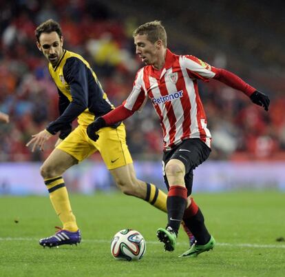 Muniain conduce el balón ante la mirada de Juanfran