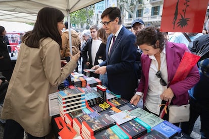 El primer secretario del PSC, Sañvador Illa, junto a la portavoz parlamentaria Alícia Romero, conversa con una librera en una parada de Sant Jordi. / PSC