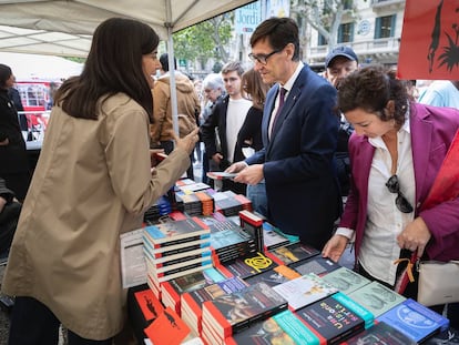 El primer secretario del PSC, Sañvador Illa, junto a la portavoz parlamentaria Alícia Romero, conversa con una librera en una parada de Sant Jordi. / PSC