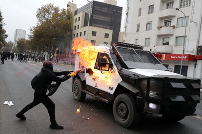 Un manifestante rocía con pintura un vehículo de la policía antidisturbios de Chile, durante la manifestación del Primero de Mayo.