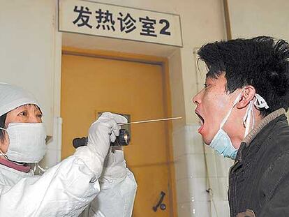 Un médico chino hace una prueba de la gripe aviar a un paciente en Shangai.