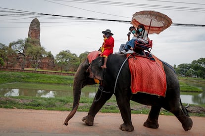Dos turistas sobre un elefante en la ciudad de Ayutthaya, Tailandia, el pasado 14 de junio.