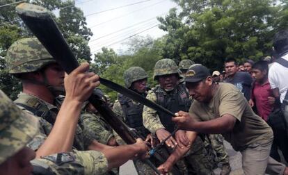 Soldados mexicanos forcejean con un guardia comunitario en Guerrero.