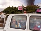 Residents leave their house as lava continues to flow from an erupted volcano, in La Mancha on the island of La Palma in the Canaries, Spain, Friday, Sept. 24, 2021. A volcano in Spain’s Canary Islands continues to produce explosions and spew out lava, five days after it erupted. Two rivers of lava continue to slide slowly down the hillside of La Palma on Friday. (AP Photo/Emilio Morenatti)