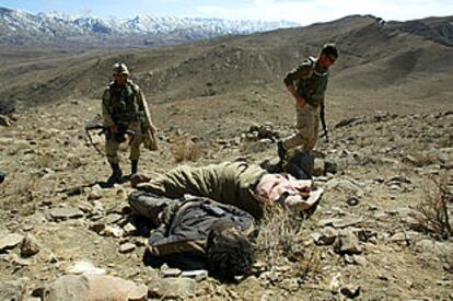Soldados estadounidenses observan el cuerpo de un combatiente de Al Qaeda en Afganistán.