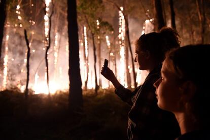 Residentes observan un incendio forestal en Nulla Vale (Australia). Los 200 incendios que ardieron en el Estado de Victoria, en el sureste de Australia, han arrasado una vivienda y amenazan a otras 190 propiedades, avivados por una ola de calor.