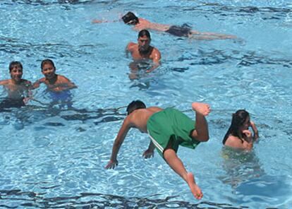 Un niño salta a la piscina del lago de la Casa de Campo de Madrid.