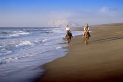 Un paseo a caballo por la playa de Sotogrande, con la roca de Gibraltar al fondo.