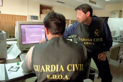 Dos agentes de la Guardia Civil rastrean delitos informáticos cometidos a través de Internet.