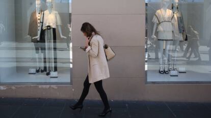 Una mujer pasa por delante de los escaparates de una tienda, en Madrid.