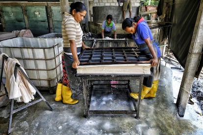 El método que siguen es artesanal y no ha cambiado mucho desde la invención del papel en China en el año 105 d.C. En la imagen, dos trabajadoras prensan manualmente las hojas de papel para quitarles el agua.