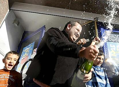 El propietario de la administración número 1 de Sant Quirze del Vallés (Barcelona), que ha vendido 59 series del número 32.365, agraciado con el Gordo de Navidad, por lo que han repartido la mayor parte del primer premio de la lotería navideña, descorcha una botella de champán para celebrarlo.
