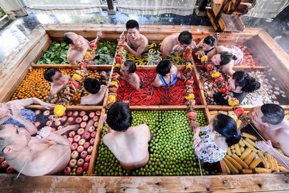 Varias personas disfrutando de un baño en una piscina de aguas termales con forma de olla en un hotel en Hangzhou, en la provincia china de Zhejiang.