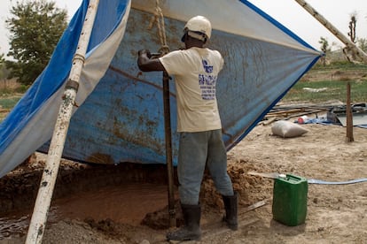 Un trabajador de GSF sujeta la 'nariz' de la excavación que están realizando en el huerto de Fiankala. La función de quien está al mando es clave: mientras otros diez hombres tiran de la cuerda para perforar, éste se encarga de que la broca se mueva de manera totalmente vertical y controla que no haya atascos.