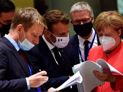 El presidente Pedro Sánchez (izquierda), el presidente francés, Emmanuel Macron, y la canciller alemana, Angela Merkel, examinan documentos durante la cumbre de la UE en Bruselas este lunes.